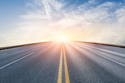 Paved road leading to sunshine/light 